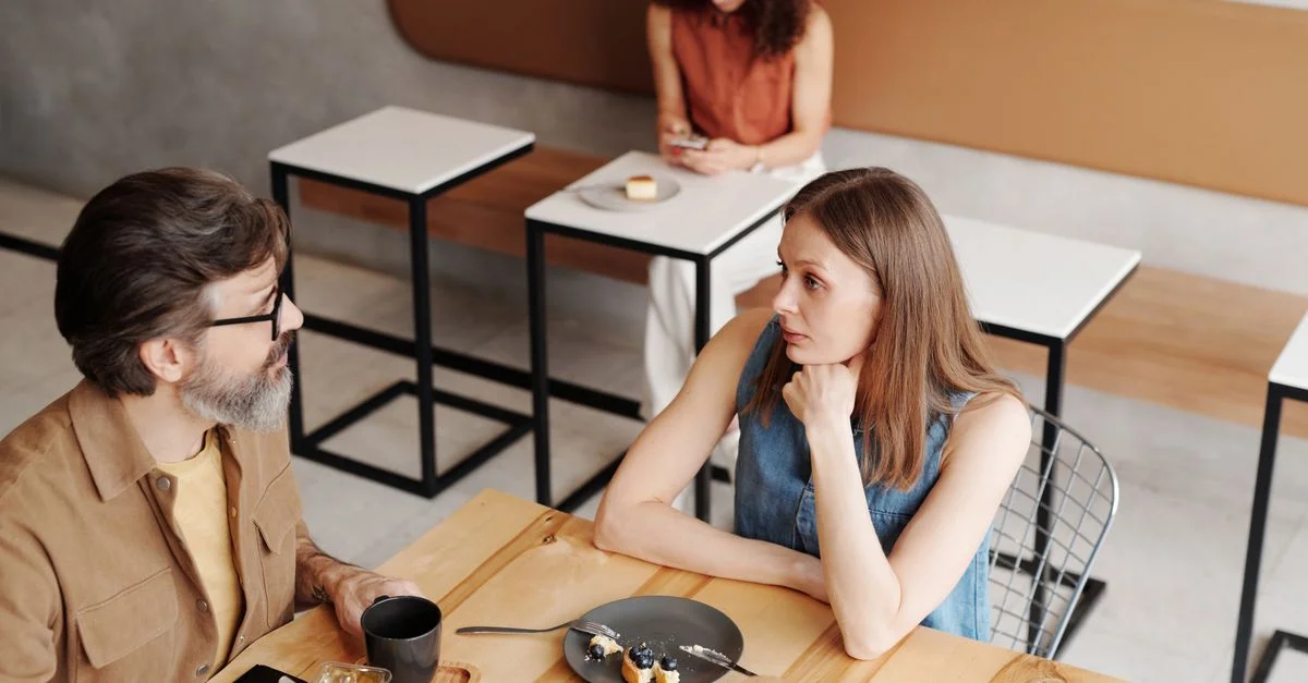 Un homme et une femme discutent autour d'un petit-déjeuner dans un café élégant.
