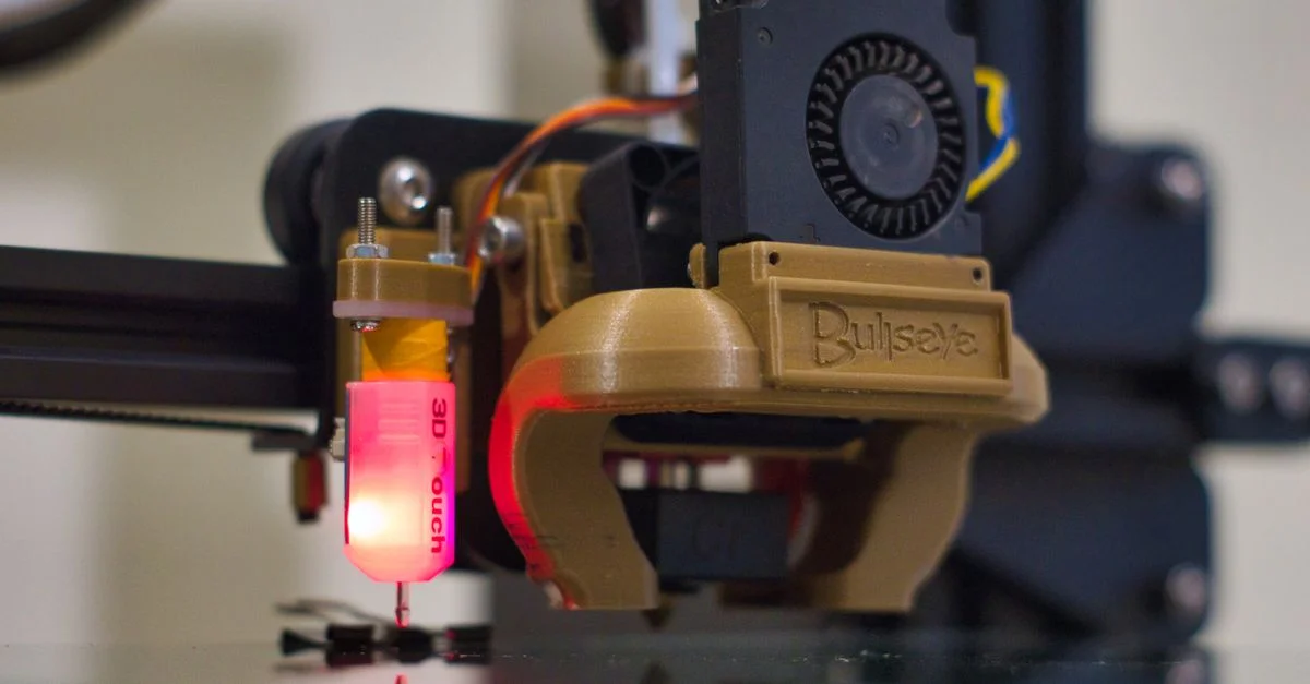 Prise de vue détaillée d'une buse d'imprimante 3D en fonctionnement dans un environnement d'atelier.